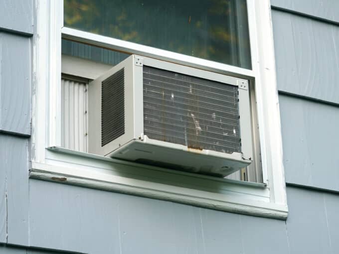 old air conditioner installed on rustic house window