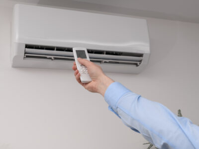 Modern remote controlled home air conditioner hanging on the wall, remote control