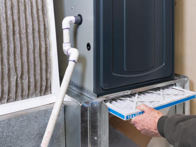 man replacing furnace filter